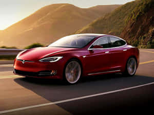 紅色Tesla Model S在日落時分在山區高速公路上飛馳。