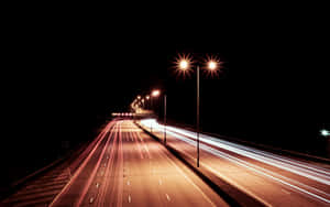 夜晚高速公路，街燈下紅色和白色汽車燈光形成條紋。