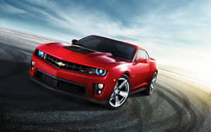 紅色雪佛蘭Camaro ZL1在藍天下沿著濕滑賽道疾馳。 — 汽車 壁紙