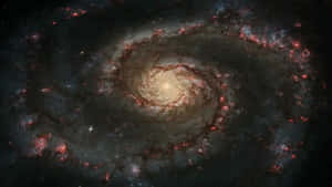 一個在深空中帶有發光旋臂的螺旋星系。 — 行星 壁紙