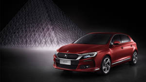 紅色 DS 4S 汽車放置在羅浮宮金字塔前，處於黑暗的工作室環境中。