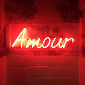 紅色霓虹燈牌顯示 Amour，背景為花卉壁紙和瓷磚牆。 — 霓虹 壁紙