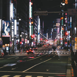 東京夜晚街道，閃爍霓虹招牌和行駛中的汽車。