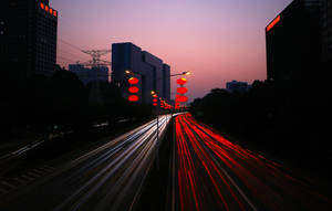 黃昏時分的城市高速公路，移動車輛的光跡和發光的紅色燈籠。 — 極光 壁紙