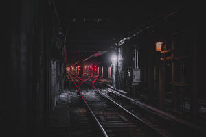 地鐵列車燈光在黑暗的地下隧道中發出紅光。
