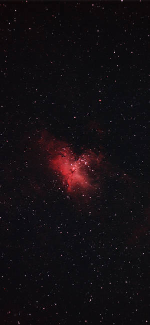 夜空中無數星星環繞的發光紅色星雲。