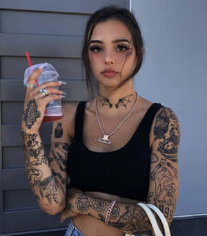 紋身女子手持飲品靠著灰色牆壁。 — 紋身 壁紙