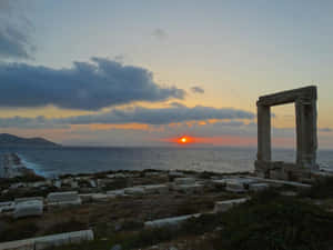 古老石頭廢墟在黃昏時分框住海上的夕陽。