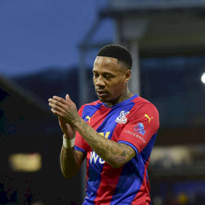 足球運動員在黃昏的球場上拍手，身穿紅藍球衣。 — 運動 壁紙