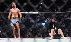 MMA拳手在八角籠內慶祝擊敗倒下的對手