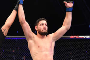 UFC鬥士在八角籠內高舉雙臂慶祝勝利。