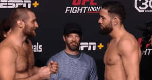 兩名男性MMA拳手在UFC記者會上對峙，中間有裁判。