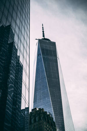 世界貿易中心一號大樓摩天大樓在多雲的天空下高聳於城市建築之上