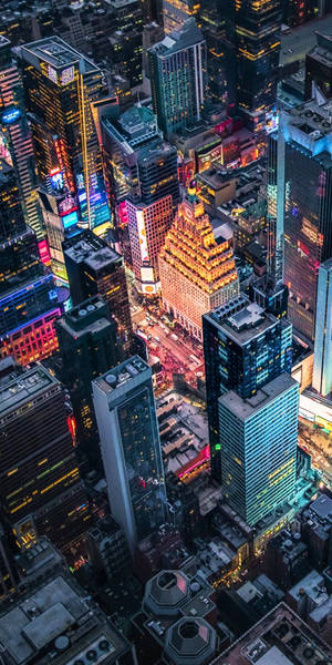 密集市區的夜間鳥瞰圖，摩天大樓燈火通明，街道繁忙。