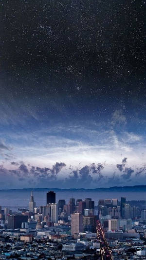 城市天際線，星空下，發光的街燈和縷縷雲彩。