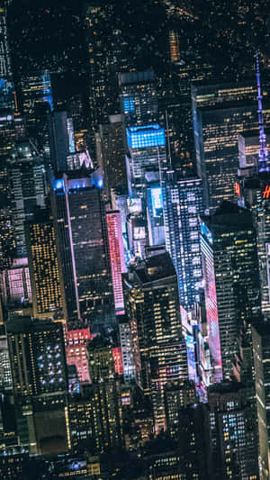 夜晚密集城市天際線的鳥瞰圖，摩天大樓燈火通明。 — 美學 壁紙