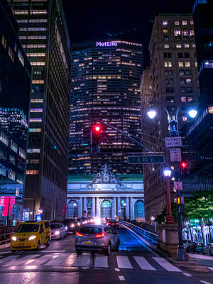 夜晚的城市街道，有發光的建築物和一輛黃色出租車。
