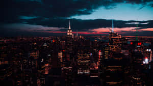 紐約市黃昏時分的天際線，建築物閃閃發光，雲彩色彩繽紛。