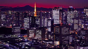 黃昏時分的東京城市燈光，背景是富士山。
