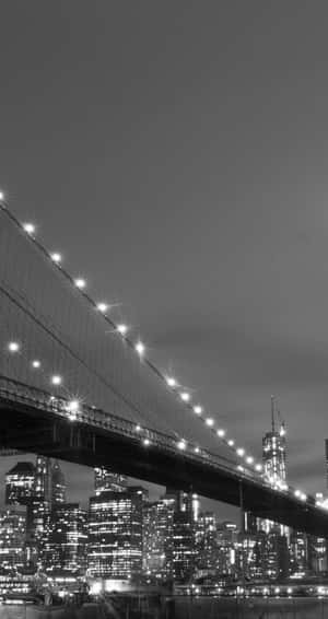 夜晚的布魯克林大橋，帶有發光燈光和單色城市天際線。