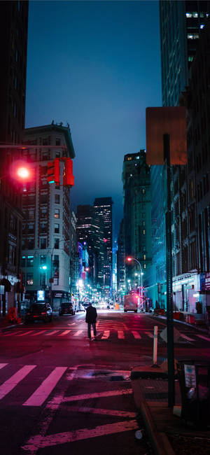 一個人在夜晚的雨中城市街道上，在紅色交通燈下過馬路。 — 紐約市 壁紙
