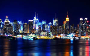 紐約天際線的夜景，建築物發光，水面倒影。 — 紐約市 壁紙