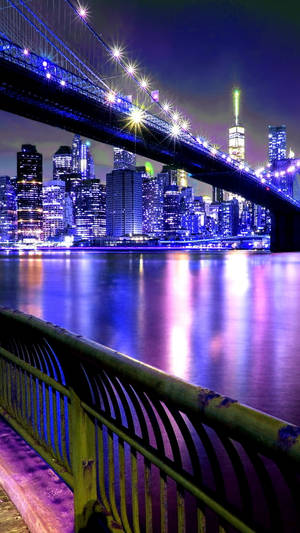 燈火通明的橋樑和城市天際線倒映在水中的充滿活力的夜景。