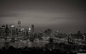紐約市天際線的夜晚黑白景觀，有燈光建築和橋樑。 — 紐約市 壁紙
