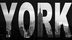 紐約的黑白城市景觀，帶有拼出YORK的大文字疊加。