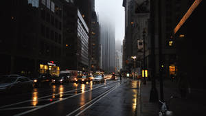 黃昏時分的城市街道，下雨，濕路面，霧濛濛的摩天大樓。