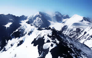 積雪的山脈，山峰尖銳，天空清澈湛藍。