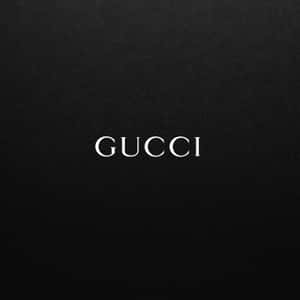 黑色紋理布料上的白色 Gucci 標誌。