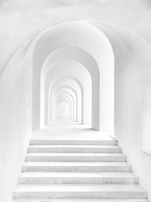 白色樓梯在極簡主義建築中穿過重複拱門的隧道。 — 白色美學gif 壁紙