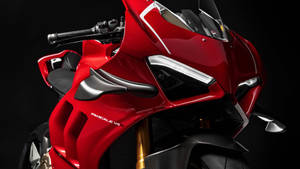 紅色 Ducati Panigale V4R 運動電單車，帶有碳纖維細節和金色前叉。