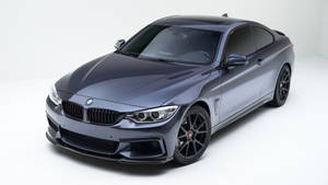 啞光灰色BMW雙門轎跑車，黑色輪圈，在白色工作室環境中。