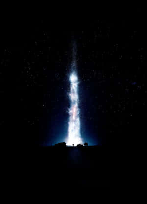 兩個人仰望夜空中發光的垂直星流。