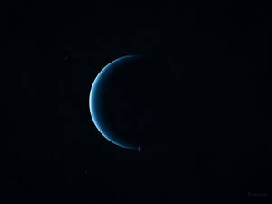 一顆發光的藍色新月形行星，帶有一顆小衛星，在繁星點點的虛空中。