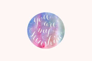 圓形水彩藝術品，帶有草書文字，寫著 you are my sunshine。