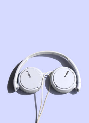 白色Sony耳機在薰衣草背景上，帶有柔和陰影。 — OnePlus Pad 壁紙