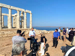 記者在海邊古老寺廟遺址進行採訪。 — 藍天 壁紙