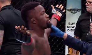 UFC拳手在八角籠中慶祝勝利，裁判停止比賽。