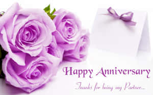 帶有露珠的薰衣草玫瑰和一張寫著 Happy Anniversary 的卡片。