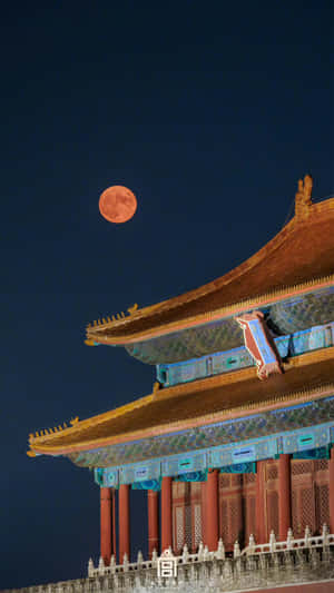 一輪滿月橙色月亮在夜晚升起在雄偉的傳統中國宮殿屋頂之上。 — 月亮 壁紙