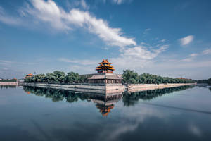 傳統中式宮殿倒映在平靜的水面上，天空中有條紋狀的雲彩。 — 藍天 壁紙