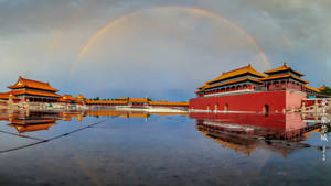 紫禁城上的雙彩虹，其紅牆和金頂倒映在濕潤的地面上。