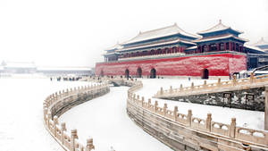 積雪的石橋通向冬日故宮的紅牆。