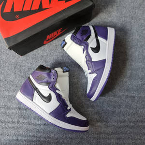 紫色、白色和黑色的Nike Air Jordan運動鞋，連原裝盒放在灰色地毯上。