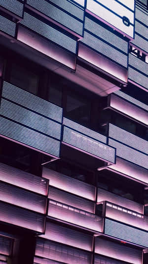 夜晚現代建築物外牆，帶有發光的紫色和白色水平燈光。