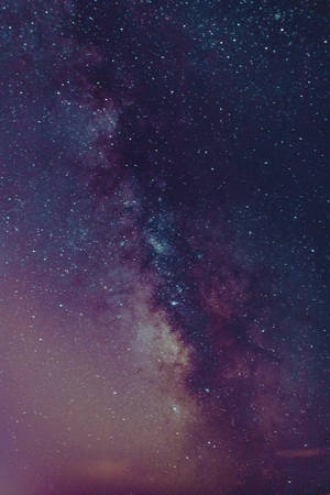 銀河系在黑暗的夜空中散發著紫色和藍色的星光。