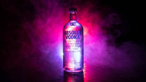 Absolut Vodka 酒瓶在煙霧瀰漫的黑暗中，被霓虹燈照亮。